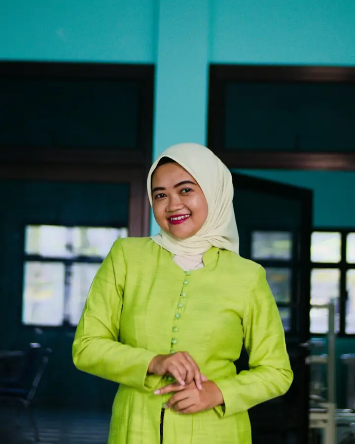 Guru berkerudung tersenyum di pintu sekolah