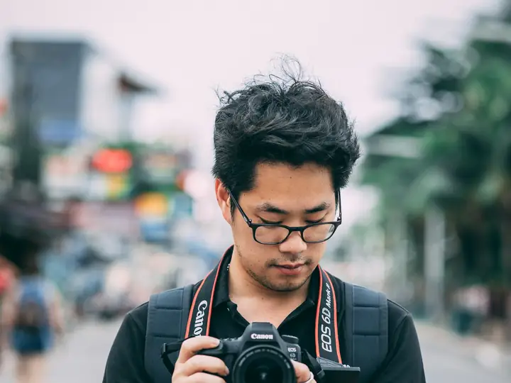 Fotografer memeriksa hasil jepretannya di jalan